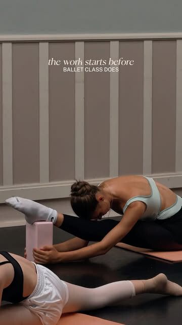 Des élèves de ballet s’étirent sur des tapis avant le cours.